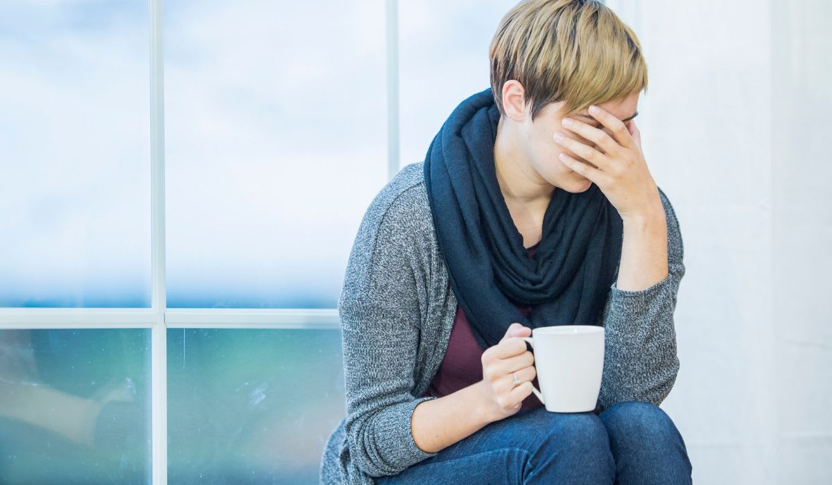 sad woman drinking a cup of coffee